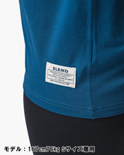 ELEIKO 1957 Tシャツ ユニセックス ブルー 裾タグ部分をクローズアップしブランドネームと縫製ディテールを確認できる構図