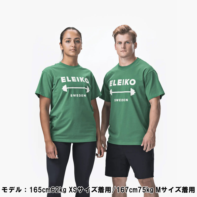 ELEIKO 1957 Tシャツ ユニセックス グリーン 男女モデル正面立ち姿でロゴとバーベルプリントを強調した全身コーディネート