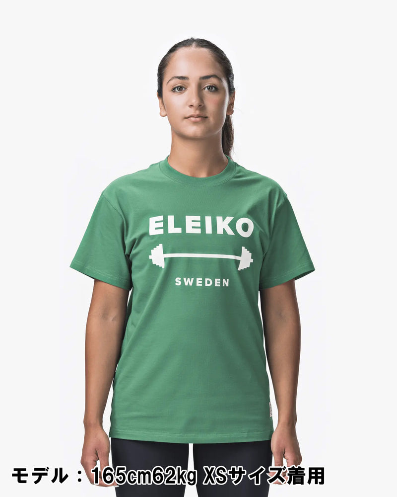 ELEIKO 1957 Tシャツ ユニセックス グリーン 女性モデル正面上半身でロゴとバーベルデザインが中央に配置された着用スタイル