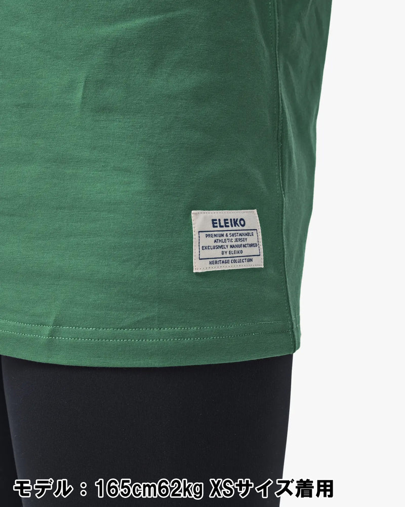 ELEIKO 1957 Tシャツ ユニセックス グリーン 裾タグ部分をクローズアップしブランドネームと縫製ディテールを確認できる構図