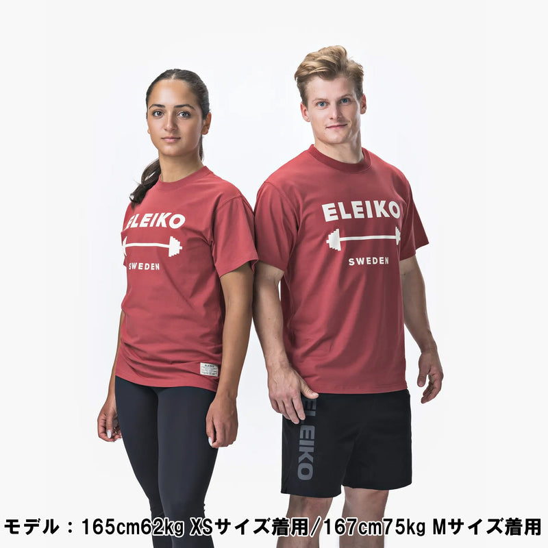 ELEIKO 1957 Tシャツ ユニセックス レッド 女性モデル正面上半身でロゴとバーベルデザインが中央に配置された着用スタイル