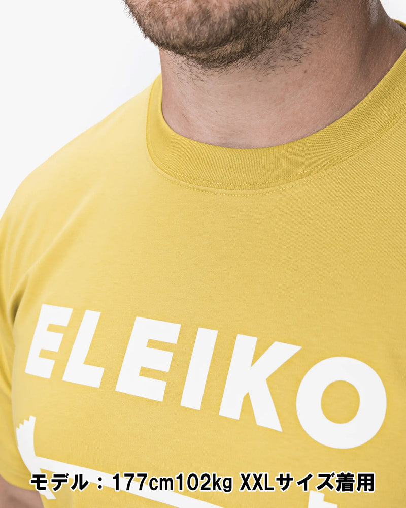 ELEIKO 1957 Tシャツ ユニセックス イエロー 裾タグ部分をクローズアップしブランドネームと縫製ディテールを確認できる構図
