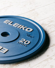 ELEIKO 新型パワーリフティングコンペティションプレート IPF公認品 青 斜め上から捉えた20kgウェイトプレートの表面ディテール、ELEIKOロゴと重量表示、中央スリーブ穴周辺の質感が分かるクローズビュー