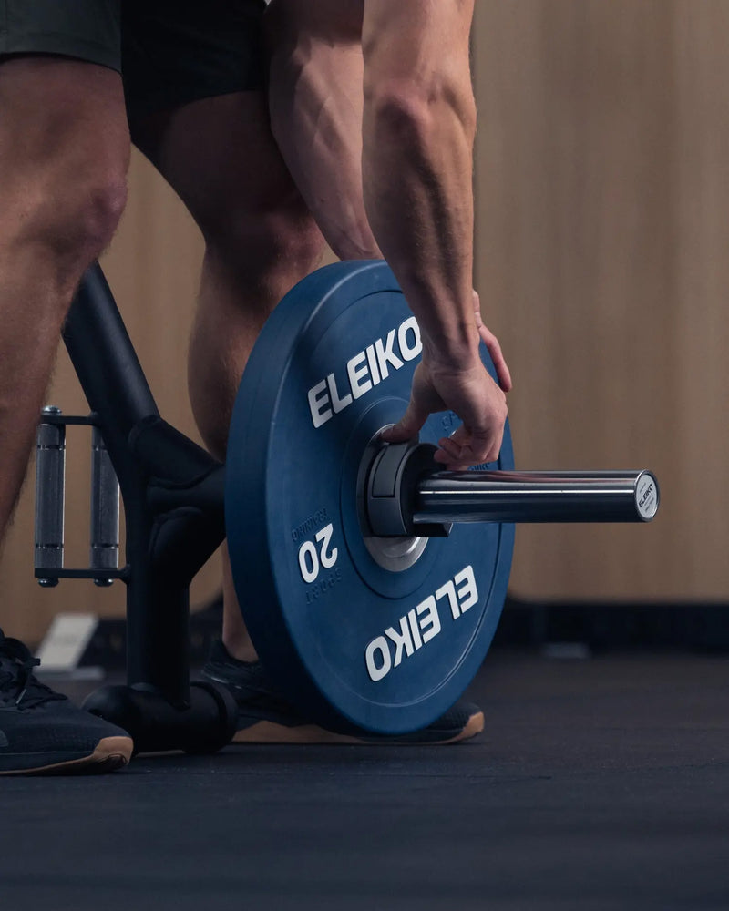 ELEIKO オープンカラー ブラックをトレーニング器具に装着した状態を斜め前から捉えた構図。ELEIKOプレート横でバーベルシャフトを固定するクイックロック式カラーの使用状態が分かる構図
