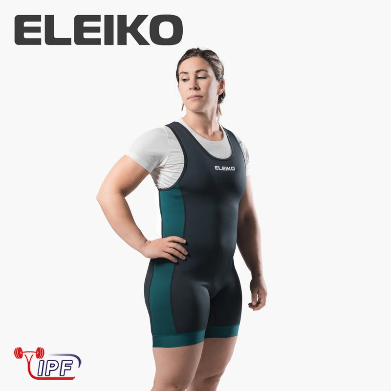 ELEIKO パワーリフティング シングレット IPF公認品 ストロングブルーを女性モデルが正面斜めから着用した全身構図。胸のELEIKOロゴと太腿丈のコンプレッションフィットが分かるシングレット