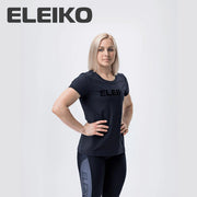 ELEIKO Tシャツ ウィメンズ ブラック 正面やや斜めから上半身と全体シルエットを捉えロゴ配置とフィット感が分かる着用スタイル