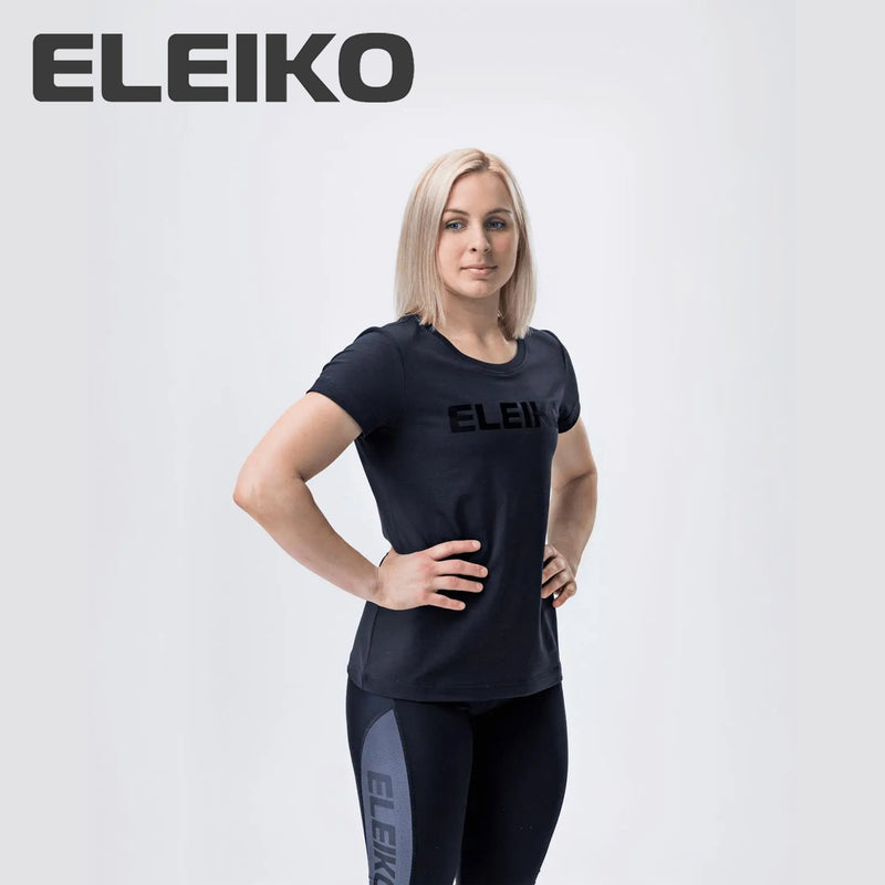 ELEIKO Tシャツ ウィメンズ ブラック 正面やや斜めから上半身と全体シルエットを捉えロゴ配置とフィット感が分かる着用スタイル