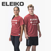 ELEIKO 1957 Tシャツ ユニセックス レッド 男女モデル正面立ち姿でロゴとバーベルプリントを強調した全身コーディネート