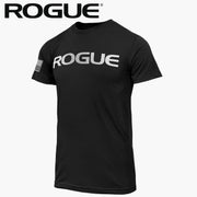 ROGUE ベーシック Tシャツ ブラック/メタリックシルバーを正面やや斜めから捉え、胸部のメタリックシルバーROGUEロゴと左袖パッチ、メンズ向け半袖シルエットが分かる構成