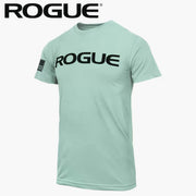 ROGUE ベーシック Tシャツ ダスティーブルー/ブラックを正面やや斜めから捉え、胸部のブラックROGUEロゴと左袖のフラッグパッチ、淡いブルーボディの色合いとメンズ向け半袖シルエットが分かる構成