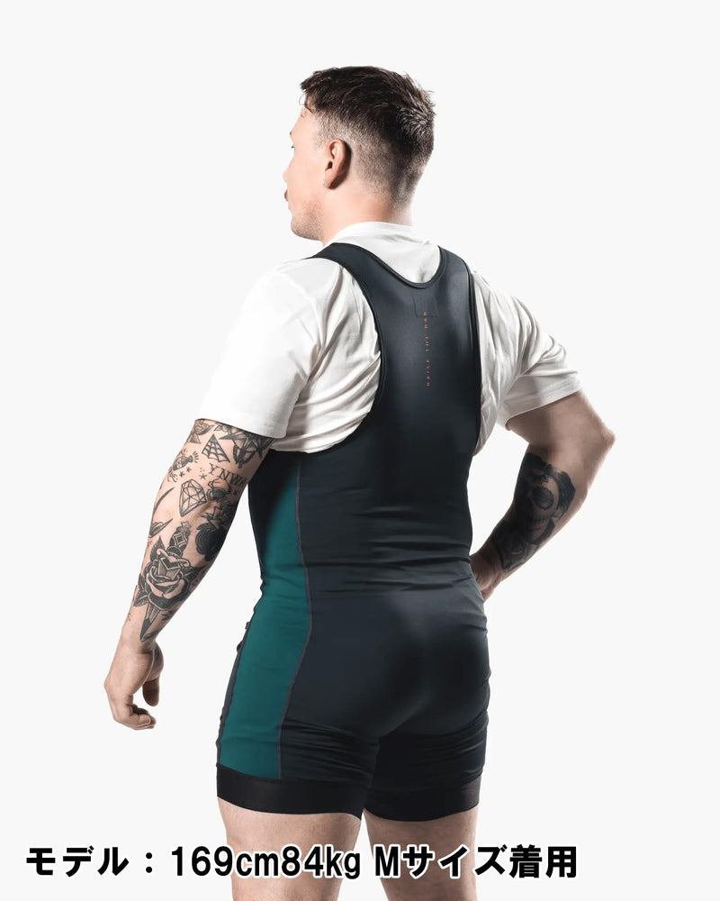 ELEIKO パワーリフティング シングレット IPF公認品 ストロングブルーを男性モデルが背面斜め後ろから着用した構図。背中のレーサーバック形状と背面中央のRAISE THE BARロゴが分かるシングレット