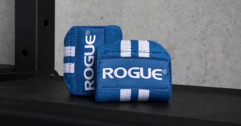 ROGUE リストラップ ブルー＆ホワイト ラック上に置いた斜め前方アングル、立て掛けた状態でロゴ面と立体感が確認できる使用シーン寄りカット