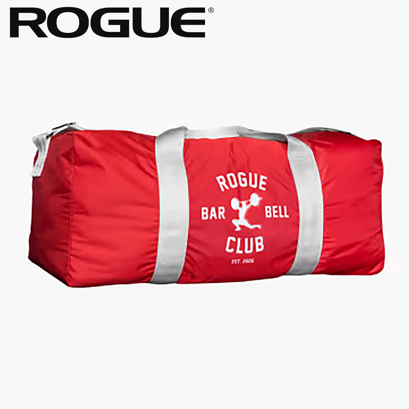ROGUE オールドスクールジムバッグ レッド、正面から水平アングルで全体を捉えた構図、中央のROGUE BARBELL CLUBロゴとグレーのストラップ、円筒形シルエットが分かる外観