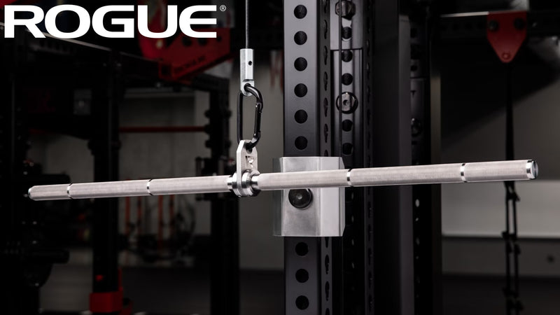 シルバーカラーのROGUE ステンレス ストレート ラットバー ケーブルアタッチメントをケーブルマシンに吊した状態を斜め前方から捉えた構図、バー全体と接続ブラケットが分かる