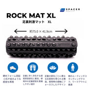 黒のROCK MAT XLを正面から見た構図で、通常サイズとの幅と奥行きの違いが想定しやすい横長設計と、全面に配置された突起パターンを確認できる大型モデルの外観