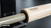 バンドベルバー バンブーバーの木製スリーブとシャフト接合部を斜め側面から拡大。ナチュラルカラーの木目とブラックの接合部、BANDBELLロゴが確認できるスペシャリティーバーベルの細部構造。