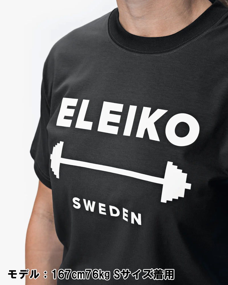 ELEIKO 1957 Tシャツ ユニセックス ブラック 胸元を斜め前から拡大しELEIKOロゴとバーベルプリントの質感を強調したディテール