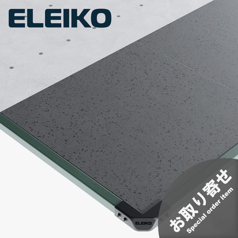ELEIKO ラックプラットフォーム ファーグリーン。斜め上方から見た外周フレームとコーナー部分。グリーンの金属製フレーム、ブラックのコーナーパーツ、グレーのラバーマット表面を備えたウェイトリフティング用プラットフォーム。