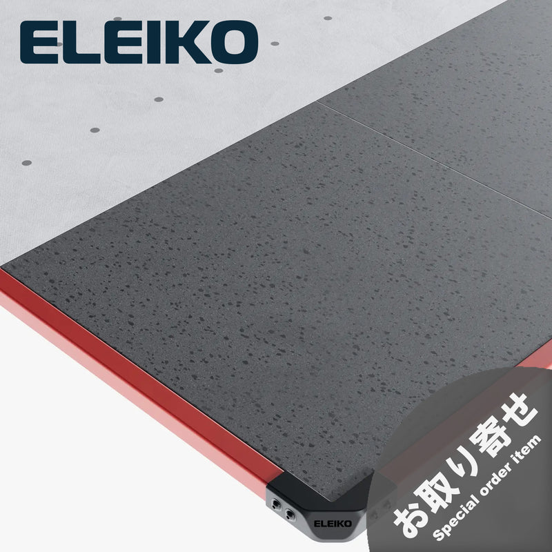 ELEIKO ラックプラットフォーム バーミリオン。斜め上方から見た外周フレームと角部分。鮮やかなレッド系の金属製フレーム、ブラックのコーナーパーツ、グレーのラバーマットを組み合わせたウェイトトレーニング用プラットフォーム。