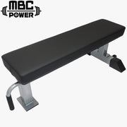 MBC コンペティションフラットベンチ シルバーグレーを斜め上から捉えた全体構図。ブラックパッドと落ち着いたグレーフレームの配色、競技向けに設計された安定感のある脚部構造が確認できる外観