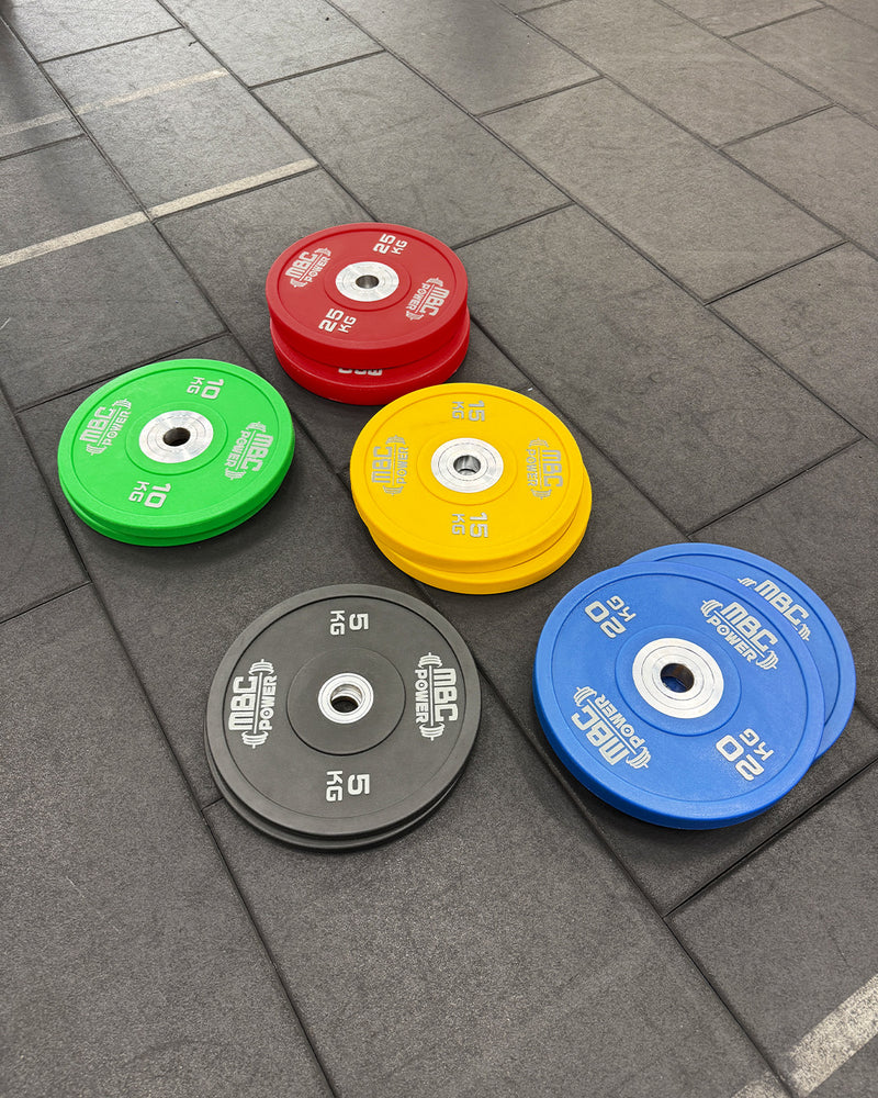 MBC ウレタンバンパープレート ブルー 20kg・イエロー 15kg・レッド 25kg・グリーン 10kgを床に並べた斜め視点、カラー別ラインナップが分かる構図