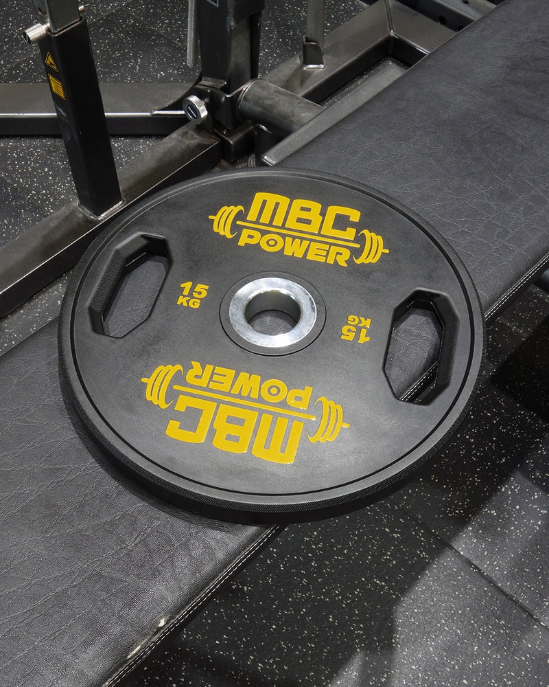 MBC ウレタングリッププレート イエロー 15kgをベンチ上に配置した俯瞰視点、中央穴とグリップ形状が分かる構図