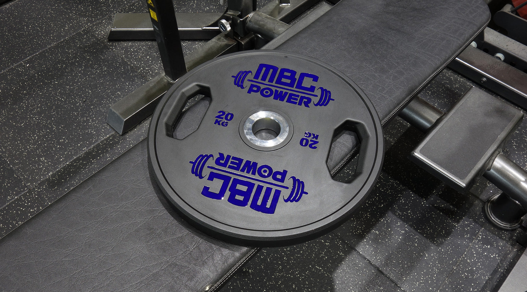 MBC ウレタングリッププレート ブルー 20kgをベンチ上に置いた斜め横からの視点、厚みと持ち手の立体感が分かる構図