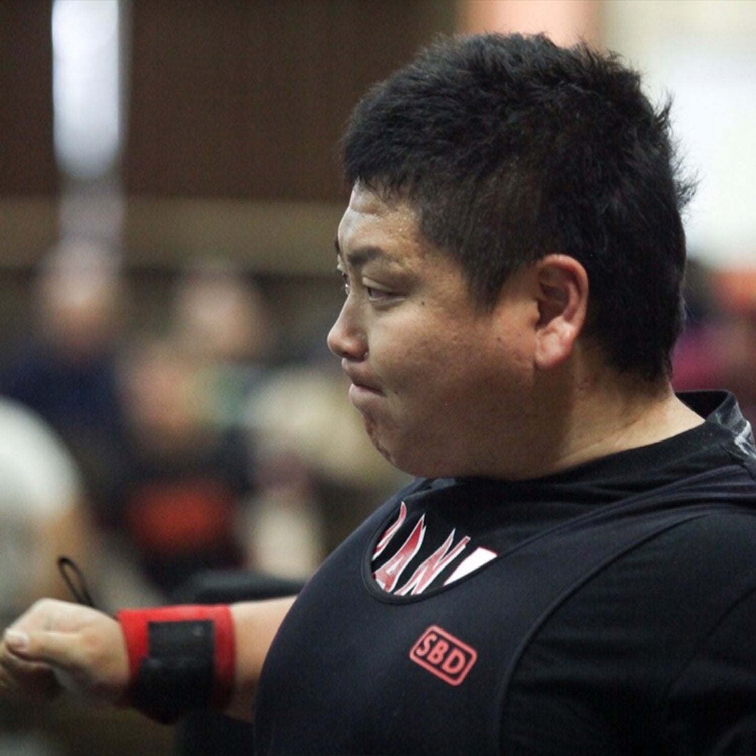 木下進人オンラインパーソナル 黒色ウェアの選手の横顔を側面から捉えたクローズアップでリストラップ装着と集中した表情が分かる描写