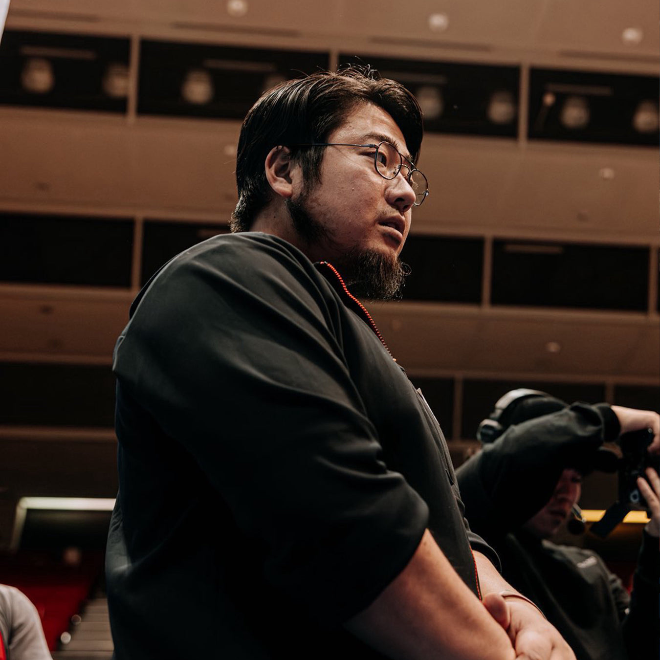中澤 悠人オンラインパーソナル 黒色ウェアのトレーナーを横から捉えたバストアップで横顔と上半身の集中した表情が分かる視点