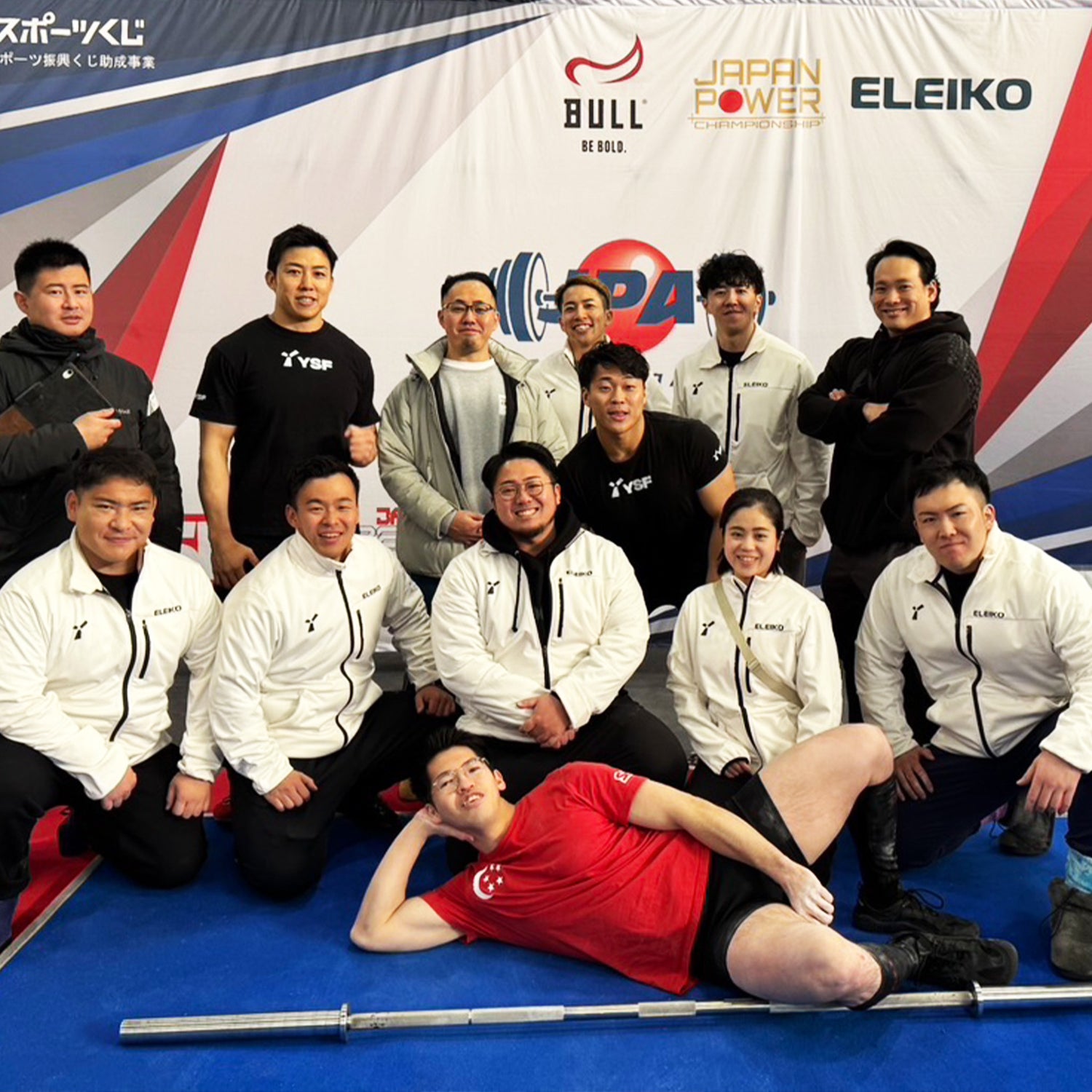 中澤 悠人オンラインパーソナル 白色ジャケットのチーム集合を正面から捉え全身と配置が分かる集合シーンで競技環境が伝わる構図