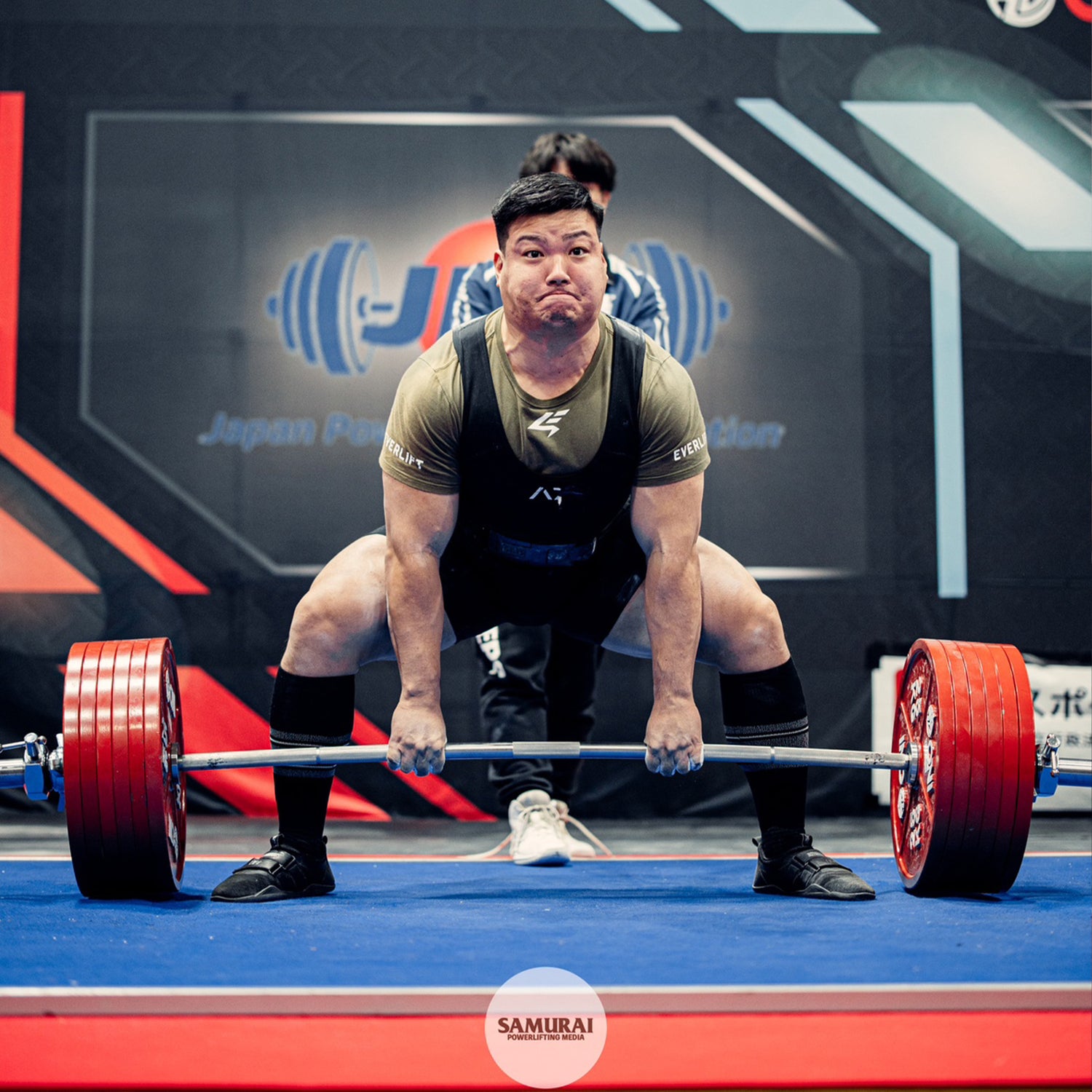 山川 太希オンラインパーソナル 黒色と緑色ウェアの山川トレーナーがデッドリフトを行う正面視点で脚部とバーベル動作が分かる構図